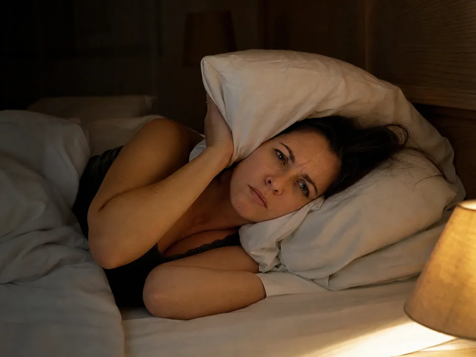 Frau liegt nachts wach im Bett